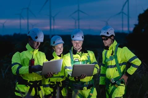 Professional engineer team at night shift. Workers in wind turbine. Technic.. Stock Photos