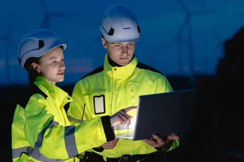 Professional engineer team at night shift. Workers in wind turbine. Technic.. Stock Photos