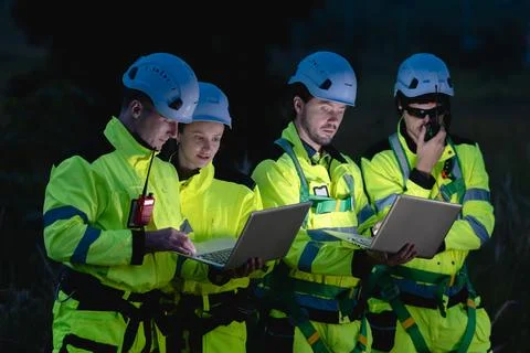 Professional engineer team at night shift. Workers in wind turbine. Technic.. Stock Photos