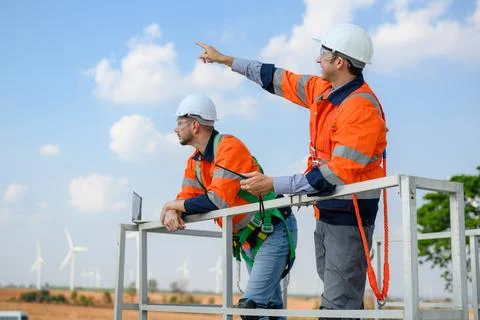 Professional engineer technician team working at wind turbine farm field Foto stock