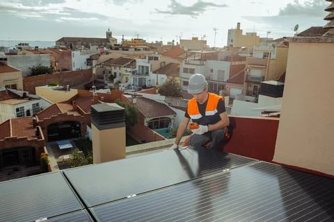 Professional engineer testing solar panels on a house roof wide angle Stock Photos