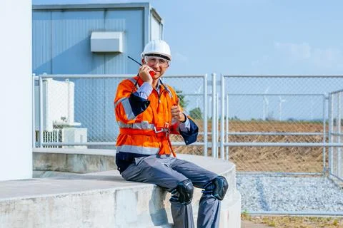 Professional engineer using walkie-talkie working at wind turbine farm Stock Photos