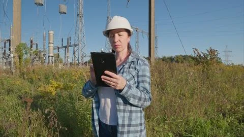 A Professional Engineer Utilizing a Tablet While Working at a Power Generation S Foto stock