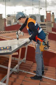 Professional engineer worker installing solar panels on a house roof Stock Photos