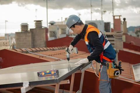 Professional engineer worker installing solar panels on a house roof Stock Photos