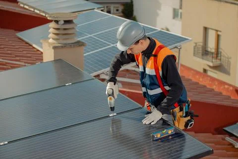 Professional engineer worker installing solar panels on a house roof Stock Photos