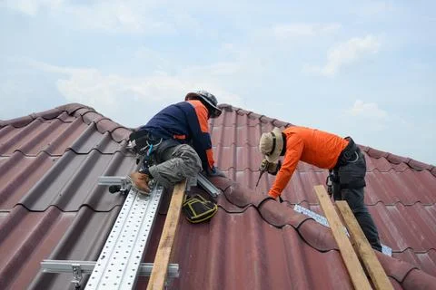Professional engineer worker installing solar panels system on rooftop Stock Photos