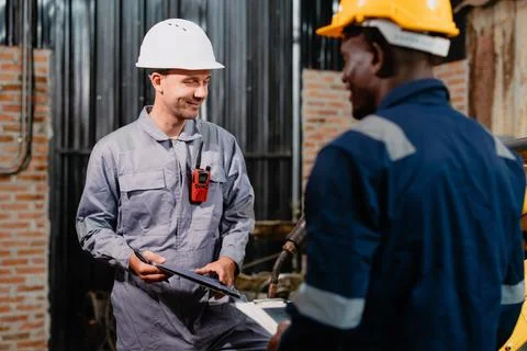 Professional engineer workers team working in metal workshop talking and wo.. Stock Photos