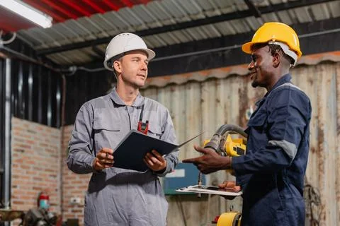 Professional engineer workers team working in metal workshop talking and wo.. Stock Photos