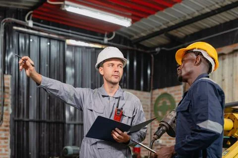 Professional engineer workers team working in metal workshop talking and wo.. Stock Photos