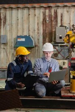 Professional engineer workers team working in metal workshop talking and wo.. Stock Photos