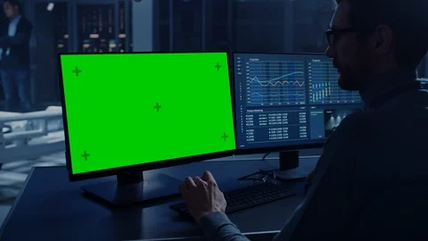 Professional Engineer Works on a Computer with Green Screen Mock Up and Tests Stock Footage 105726652