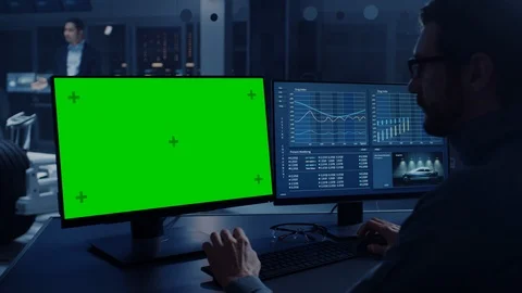 Professional Engineer Works on a Computer with Green Screen Mock Up and Tests Stock Footage 105726834