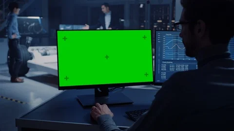 Professional Engineer Works on a Computer with Green Screen Mock Up and Tests Stock Footage 105728075