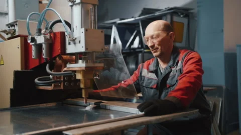 A professional engineer works with a metal sheet behind a protective shield Video stock 137654918