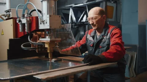 A professional engineer works with a sheet of metal behind a protective screen Stock-Footage 137273050