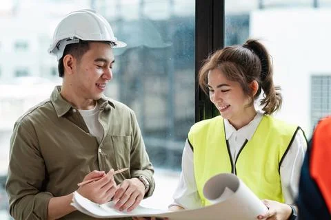 Professional Engineers Collaborating on Project Plans in Modern Office Setting Foto stock