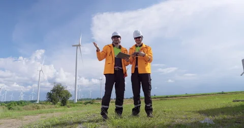 Professional engineers control drone flight near wind turbine field collect Stock Footage 330761251