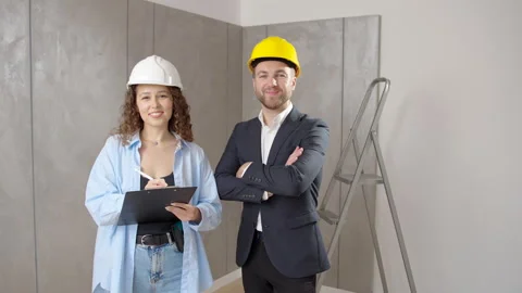 Professional engineers in hard hats discussing project looking at camera Video stock 244221291