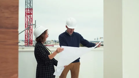 Professional engineers reviewing building plans at construction site,review.. Stock Footage 329510521