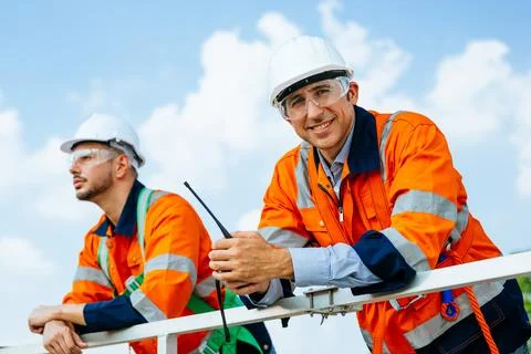 Professional engineers technicians working at wind turbine farm field Stock Photos