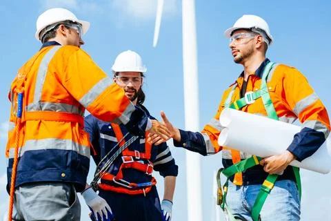 Professional engineers technicians working at wind turbine farm field Stock Photos