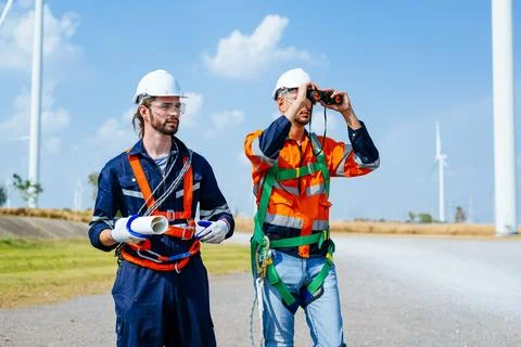 Professional engineers technicians working at wind turbine farm field Stock Photos