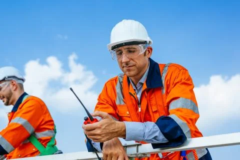 Professional engineers technicians working at wind turbine farm field Stock Photos