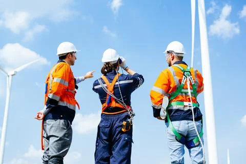 Professional engineers technicians working at wind turbine farm field Stock Photos