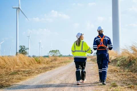 Professional engineers technicians working at wind turbine farm field Stock Photos