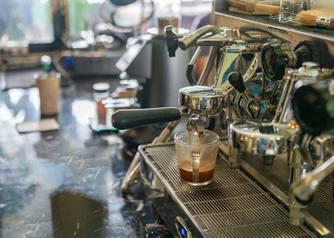 Professional espresso machine extracting a fresh shot of coffee into a clea.. Fotos Stock