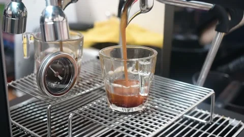 Professional espresso machine pouring strong looking fresh coffee into a glass Stock Footage 236903231