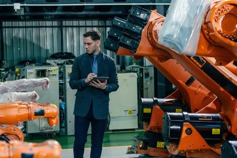 Professional evaluating robotic systems in a modern industrial facility dur.. Stock Photos