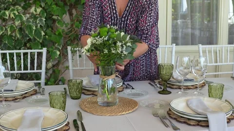 Professional event planner arranging elegant white and green floral centerpiece 库存影片 311012957