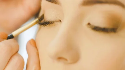 Professional Eye makeup artist applying eyeshadow powder. Beautiful woman face Video stock 74427407