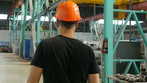 Professional factory worker in hard hat walking through manufacturing facility Stock-Footage 116260730