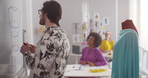 Professional fashion designers working over new sketch on white board Stock Footage 154261853