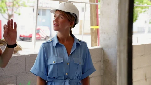 Professional female architect in hard hat inspecting a building site, discu.. Stock Footage 317643701