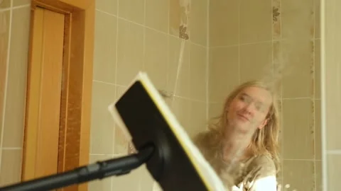 Professional female cleaner is using a steam cleaner to sanitize a bathroom Stock Footage 295059591