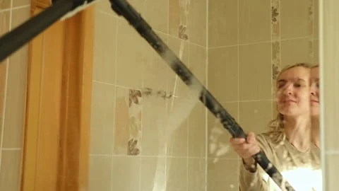 Professional female cleaner is using a steam cleaner to sanitize a bathroom Stock Footage 295934280