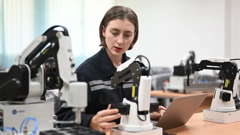 Professional female engineer with robotic machine at factory 스톡 동영상 241520127