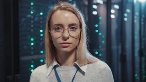 Professional female IT engineer with arms crossed staying at open rack server Stock Footage 119083776