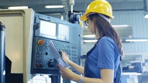 Professional Female Operator in Hard Hat Setting up/ Programming CNC Machine  库存影片 77530102