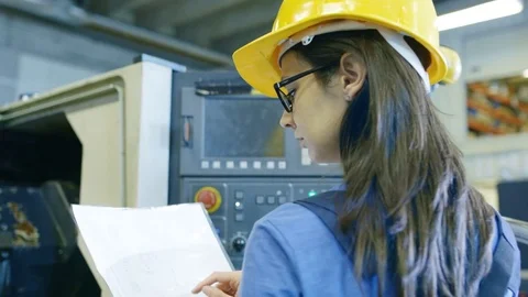 Professional Female Operator in Hard Hat Setting up/ Programming CNC Machine  库存影片 77530162