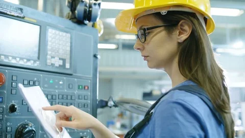 Professional Female Operator in Hard Hat Setting up/ Programming CNC Machine  库存影片 77530262