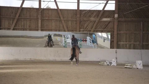Professional female rider practicing with her horse in a spacious indoor sand Stock-Footage 332650100