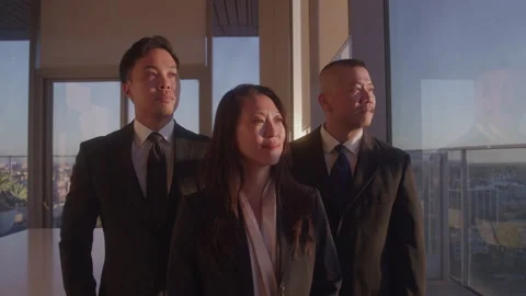 Professional Female Stands in Front of Two Professional Males near window Video stock 222006962