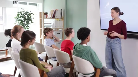Professional female teacher explaining educational topic to attentive teenage Stock Footage 341785271