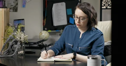 Professional Female Writing in Notebook While Working from Home Office Stock Footage 129069567