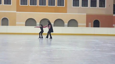 Professional figure skating coach explaining girl on skate how to move, taking Stock Footage 209480239
